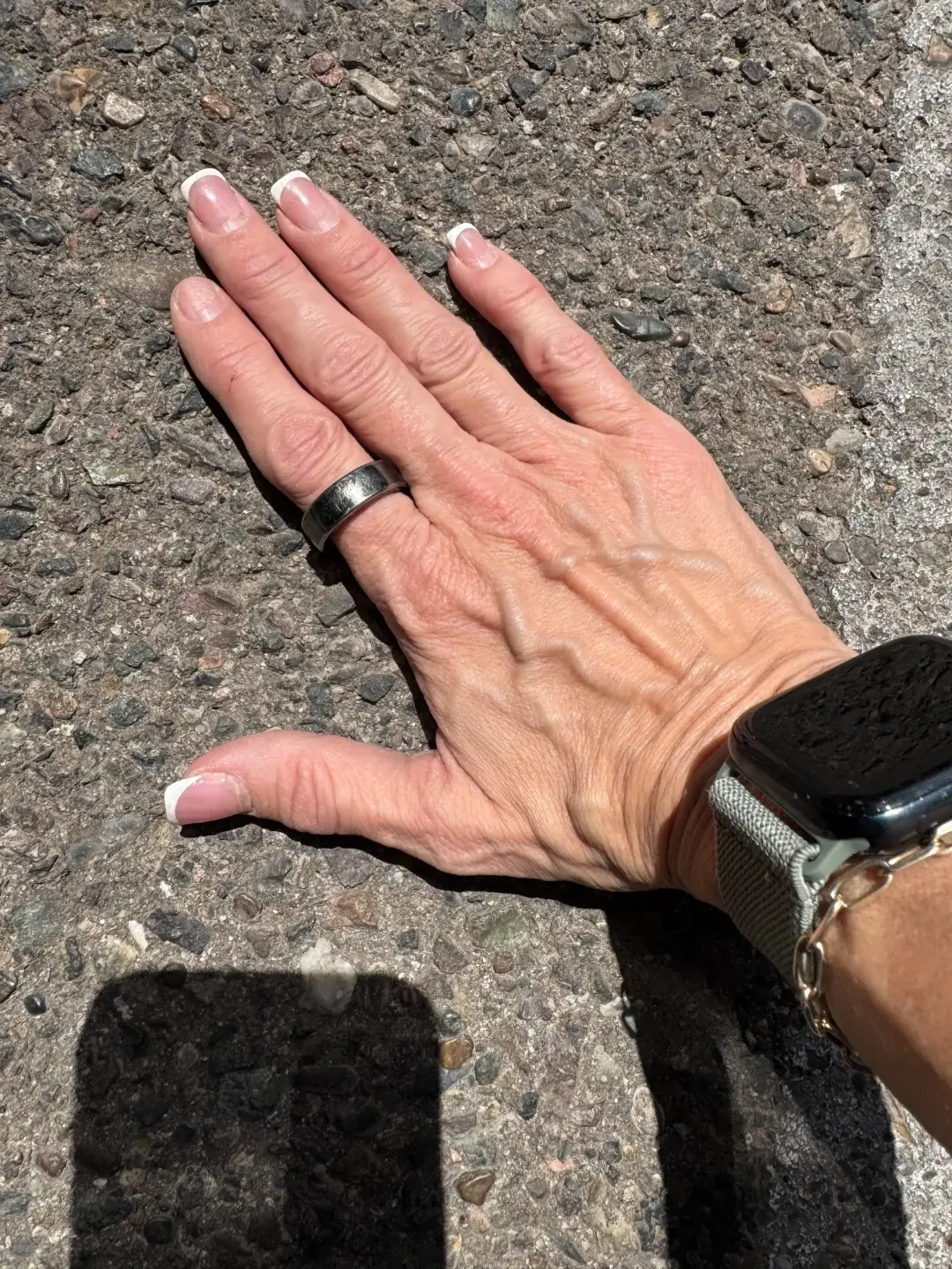 A hand checking pavement beside a parking space
