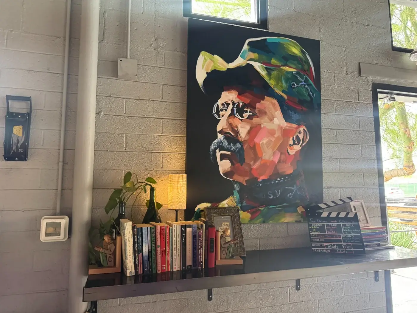 Colorful portrait painting and books inside The Theodore